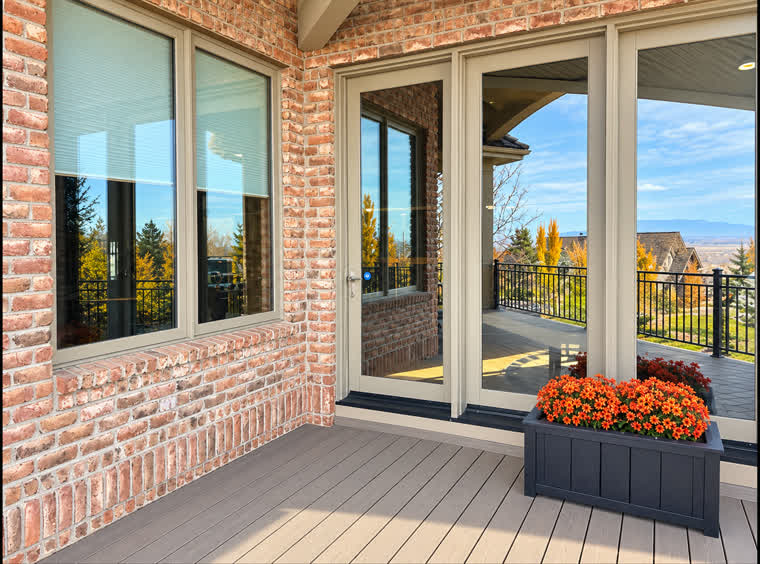 Trex Transcend Lineage deck in Biscayne outside the patio doors, with a planter of orange flowers
