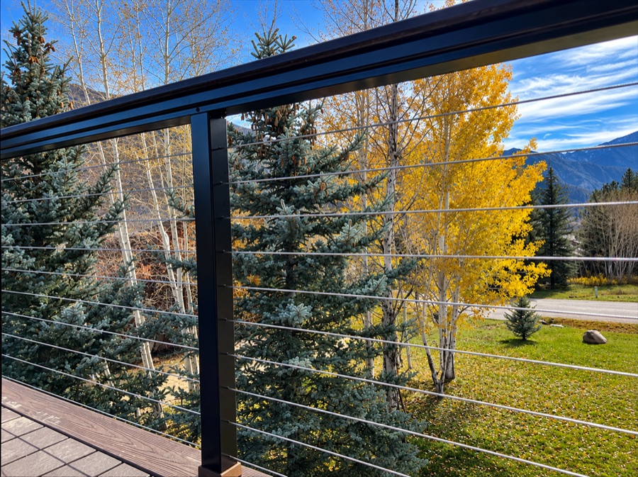 Elevated brown composite deck with black metal picket railing and wide stair run
