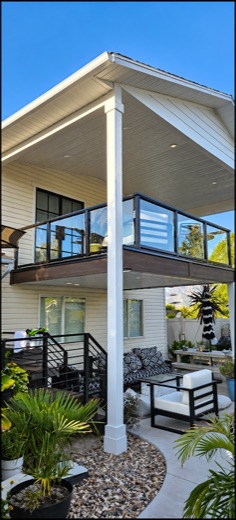 Covered second-story deck with glass panel railing and recessed lighting