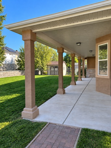 Covered walkway with stucco columns and a white tongue-and-groove ceiling