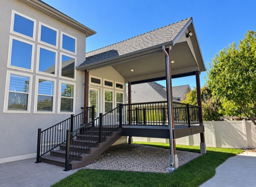 Gabled deck roof with recessed lighting over a composite deck with black railing