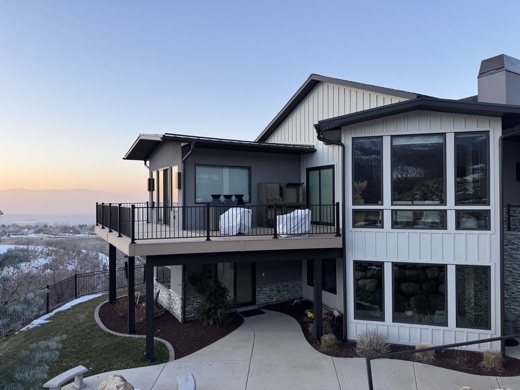 Elevated deck with black picket railing overlooking the valley at sunset