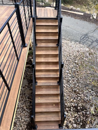 Ipe hardwood deck stairs framed by black horizontal-rod railing