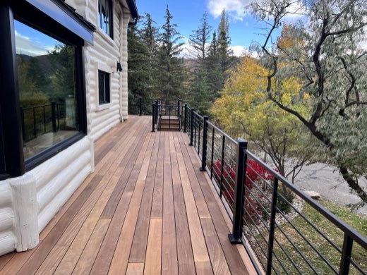 Ipe hardwood deck walkway with black horizontal-rod railing and fall color