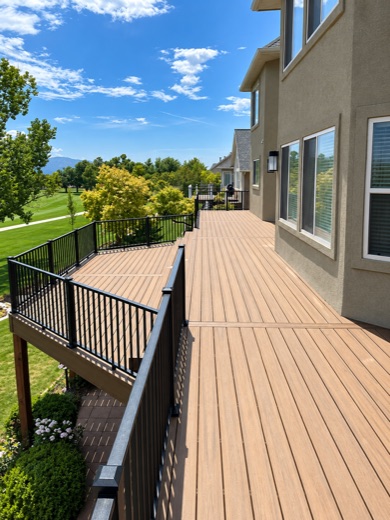 Tan composite deck walkway with black picket railing above a golf course