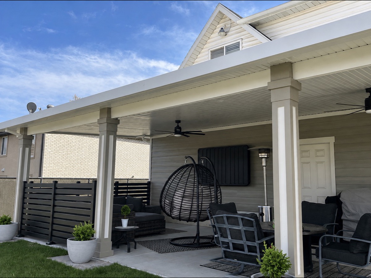 White aluminium patio cover over a furnished patio with a hanging chair