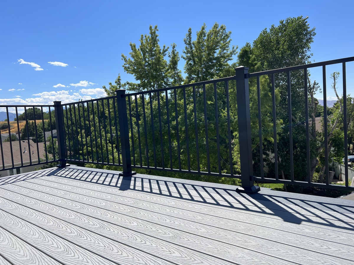 Black aluminium railing on a grey composite deck with valley and mountain views
