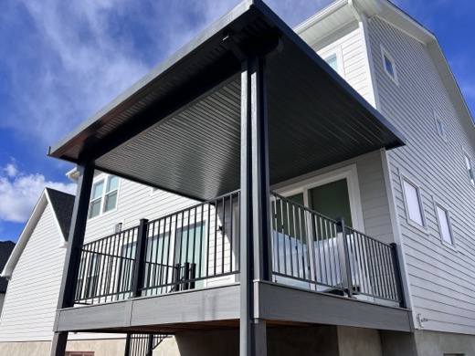 Black aluminum patio cover over a second-story composite deck