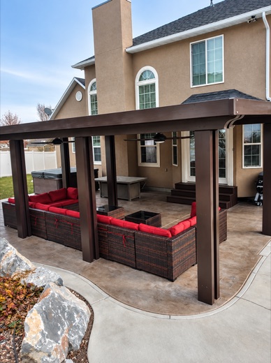 Bronze aluminum patio cover over a stamped concrete patio with lounge seating