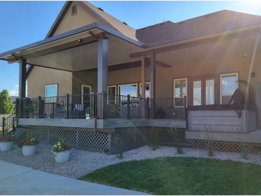 Brown aluminum patio cover over a composite deck with a hot tub