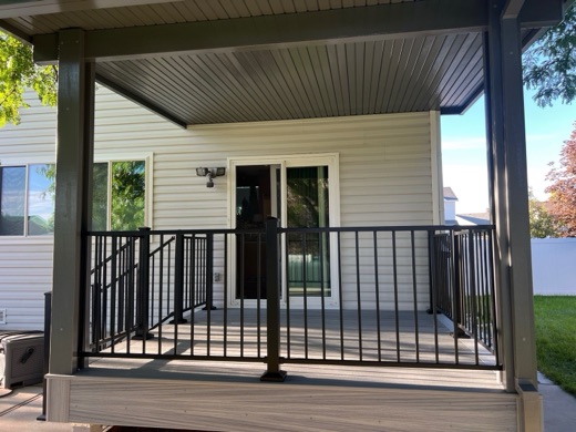 Patio cover with black picket railing over a composite deck