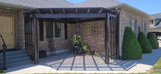 Bronze attached pergola over a brick patio