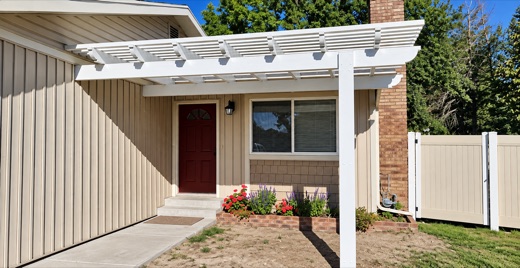 White attached pergola over a front entry walkway