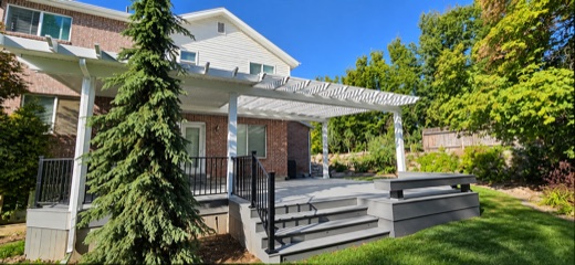 White attached pergola over a gray composite deck with wide steps