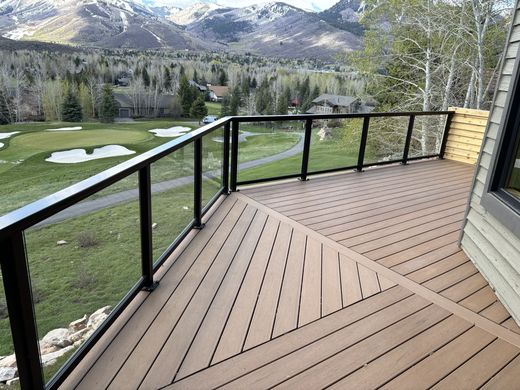 Black glass-panel railing with mountain and golf course views
