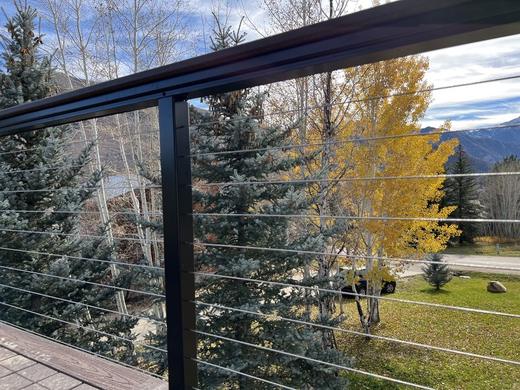 Black cable railing with flat top rail overlooking aspens and mountain slopes (Precision railing)