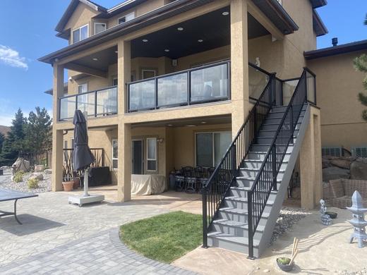 Covered upper deck with glass panel railing and black picket stair railing (Precision railing)