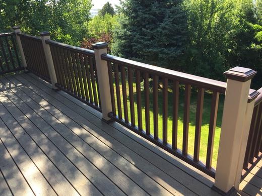 Brown composite railing with vertical pickets and post caps on gray backyard deck (Rope Swing)